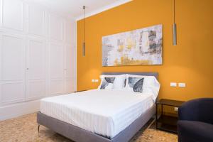 a bedroom with a white bed with an orange wall at Savoia Luxury Penthouse in Rome