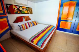 a bedroom with a bed with a colorful striped blanket at Finca Nuevo Monarca in Pereira