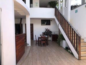 a dining room with a table and a staircase at Carpao Lodging Galapagos in Puerto Ayora