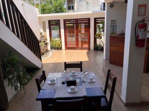 a dining table and chairs in a courtyard with a building at Carpao Lodging Galapagos in Puerto Ayora