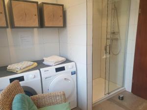 een badkamer met een wasmachine en een douche bij ROSE'S Ferienwohnung in Bernbach