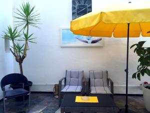 two chairs and a yellow umbrella in a room at Hotel Bismarck in Düsseldorf