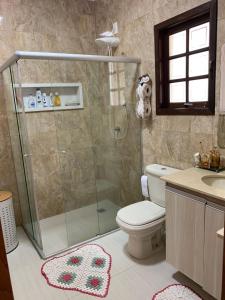 uma casa de banho com um chuveiro, um WC e um lavatório. em Chácara Morada de Cristo em Igaratá