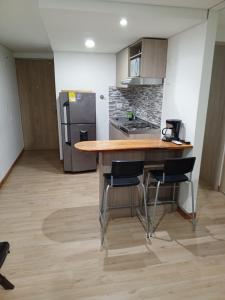 cocina con mesa de madera y 2 sillas en Apartamento Rodadero Santa Marta 902, en Santa Marta