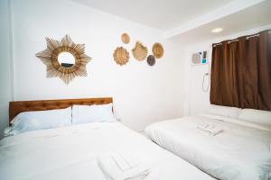 1 dormitorio con 2 camas y espejo en la pared en Villa Soledad Garden Resort, en San Pablo