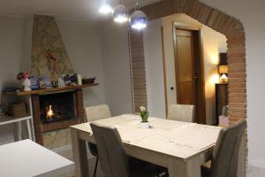 ein Esszimmer mit einem Tisch und einem Kamin in der Unterkunft Villa Severino Ferrari Anzio in Anzio