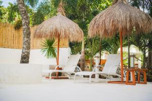 un grupo de sillas y sombrillas en una playa en Villa Soledad Garden Resort, en San Pablo