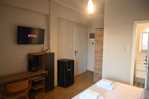 um quarto de hotel com uma cama e uma televisão na parede em SuperHost Hub #510 Plaka - Monastiraki em Atenas