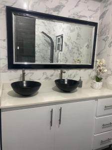 a bathroom counter with two sinks and a mirror at Villa Familiar con Piscina cerca Av Ecológica in La Ureña