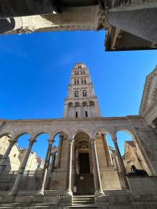 un edificio alto con una torre encima en Largo apartment in the heart of Diocletian palace en Split