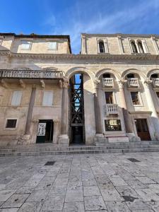 Largo apartment in the heart of Diocletian palace في سبليت: مبنى حجري كبير مع باب مفتوح