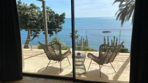 a balcony with two chairs and a view of the ocean at El jardin Botánico Villa LUZ in Altea