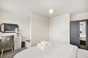 Habitación blanca con cama y espejo en Stunning 4 bed In Leicester with Garden & Parking! en Leicester