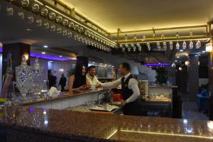 un hombre y una mujer de pie en un bar en Malabadi Hotel en Diyarbakır