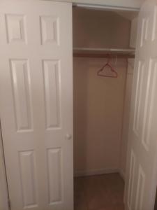 einen Schrank mit einer weißen Tür und einem Kleiderbügel in der Unterkunft Deluxe Room A 12 minutes to Ewr in Newark