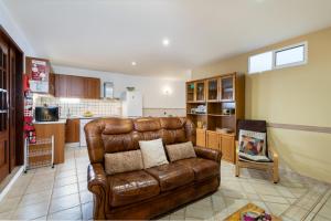 a living room with a brown leather couch in a kitchen at Apartment in a House in Tavira