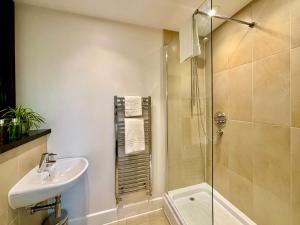 a bathroom with a shower and a sink and a toilet at Your Space Apartments - The Hamilton's in Cambridge