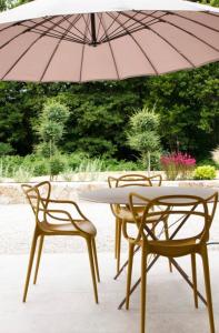 2 chaises et une table avec un parasol dans l'établissement Casa Ghjuvan Matteu, 