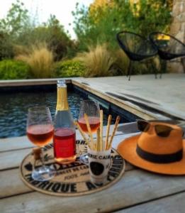 einen Tisch mit zwei Gläsern Wein und einem Hut in der Unterkunft Casa Ghjuvan Matteu 