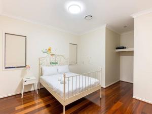 RochedaleにあるHome away from home Grand Family Mansionの白いベッドルーム(ベビーベッド付)