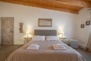a bedroom with a large bed with two towels on it at Dimoras Boutique Rooms in Olbia