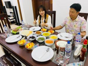 mężczyzna i kobieta siedzący przy stole z jedzeniem w obiekcie Udara Guest - Yala Safari w mieście Yala