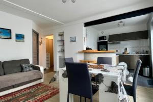 cocina y sala de estar con mesa y sofá en Cozy cocoon of love with terrace and garden, en La Rochelle