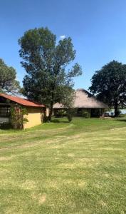 a house with a tree in the middle of a field at Vaal Haven - riverside getaway in Vanderbijlpark
