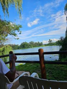a person laying on a fence looking at a lake at Vaal Haven - riverside getaway in Vanderbijlpark