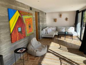 a living room with a couch and a painting on the wall at El jardin Botánico Villa LUZ in Altea