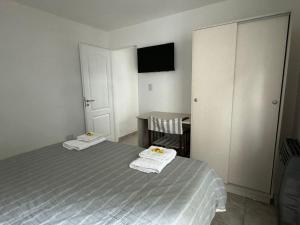 a bedroom with a bed and a table with towels at Esquel Home in Esquel