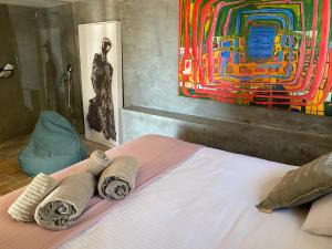a bedroom with a bed with towels and a painting at El jardin Botánico Villa LUZ in Altea