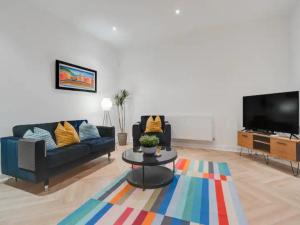a living room with two couches and a tv at Pass the Keys Golfers Haven 2 BD Flat on Hoylake Beach Parking in Hoylake