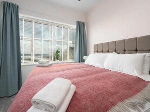 a bedroom with a large bed with a large window at Pass the Keys Golfers Haven 2 BD Flat on Hoylake Beach Parking in Hoylake