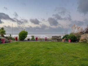 un parque con un banco y vistas al océano en Pass the Keys Golfers Haven 2 BD Flat on Hoylake Beach Parking, en Hoylake