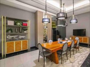 a dining room with a wooden table and chairs at 2 BR I ANDERSON I 25floor I above pakuwon mall I the biggest shopping center in Surabaya