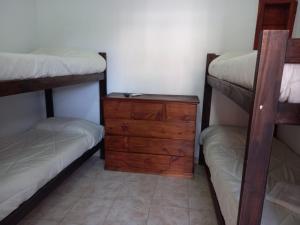 1 dormitorio con 2 literas y tocador de madera en Hotel.Aires de Libertad en San Bernardo