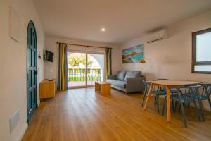 a living room with a table and a couch at Apartamentos Sol y Mar II in Cala en Blanes