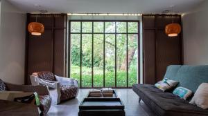 a living room with a couch and a large window at Le Moulin des Rives - Somptueuse demeure du XIIème in Romagne