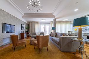 a living room with a couch and chairs and a tv at Hotel Porto Mar in Matosinhos