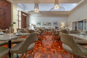 a dining room with tables and chairs and lights at Hotel Porto Mar in Matosinhos