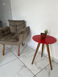 a chair and a table with a potted plant on it at Apartamento para temporada HospedagemOuroPreto202 in Ouro Preto