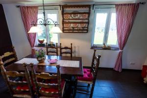a dining room with a table and chairs and two windows at Villa Pia in Reit im Winkl