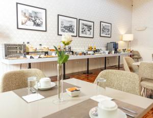 a restaurant with a table with a flower in a vase at Hotel Porto Mar in Matosinhos +52 photos