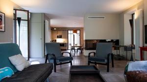 a living room with a couch and chairs and a kitchen at Le Moulin des Rives - Somptueuse demeure du XIIème in Romagne +33 photos