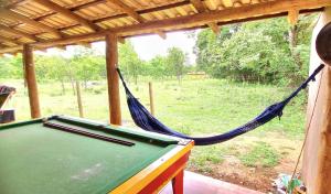 een hangmat in een huis met een pooltafel bij Rancho Sagarana in Três Marias