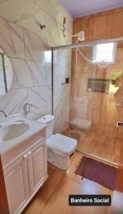 een badkamer met een wastafel, een toilet en een douche bij Rancho Sagarana in Três Marias