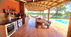 een keuken met een houten tafel en een fornuis bij Rancho Sagarana in Três Marias