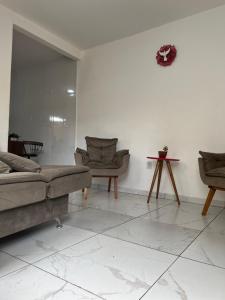 a living room with a couch and two chairs at Apartamento para temporada HospedagemOuroPreto202 in Ouro Preto