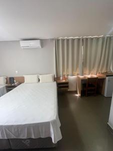 a bedroom with a large white bed and a window at Hotel Solar Bela Vista in São Paulo